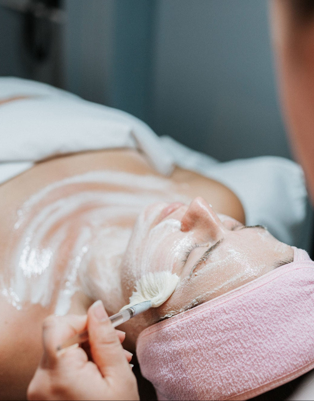 Person receiving a facial treatment with a towel draped over their head